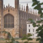 Stunning view of King's College Chapel in Cambridge, England, seen through foliage.