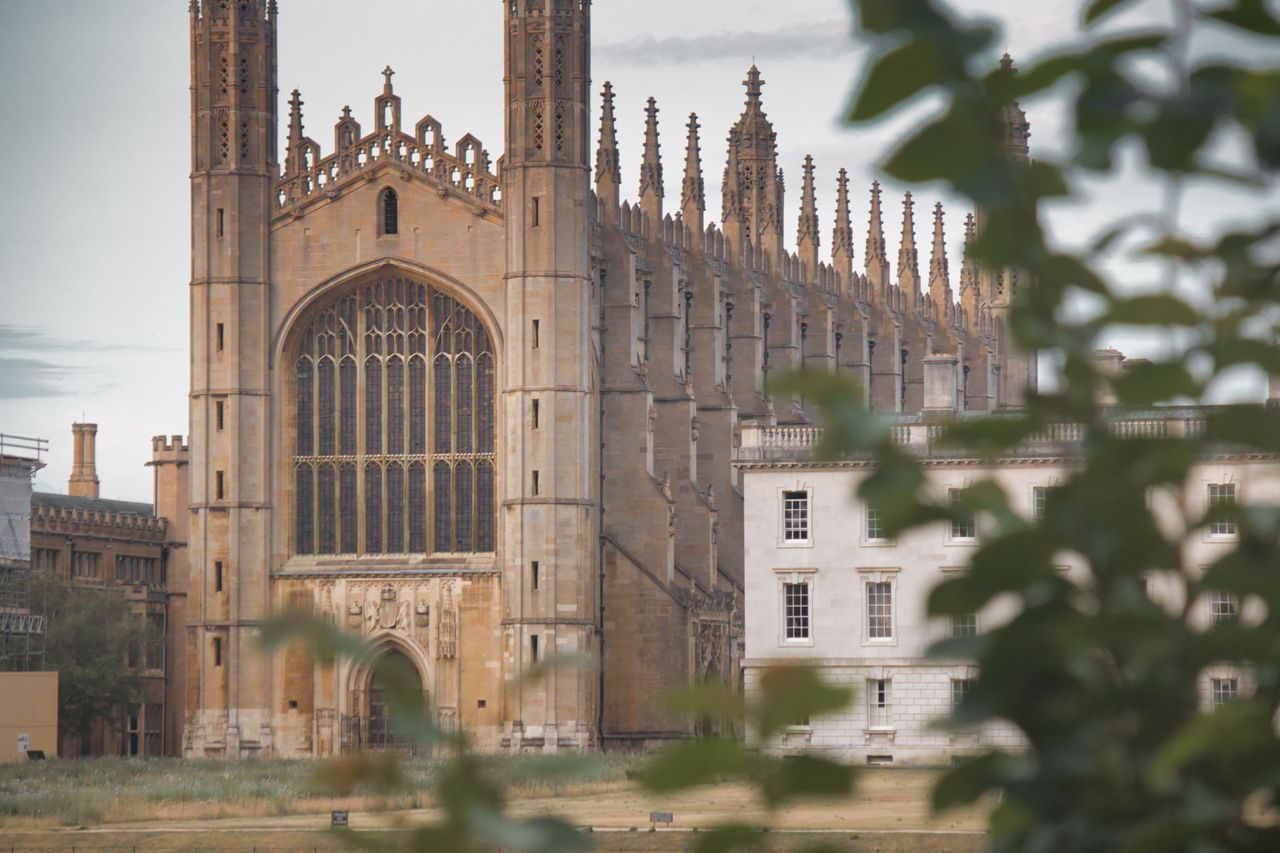 The Art of Drawing Readers In: Your attractive post title goes here Stunning view of King's College Chapel in Cambridge, England, seen through foliage.